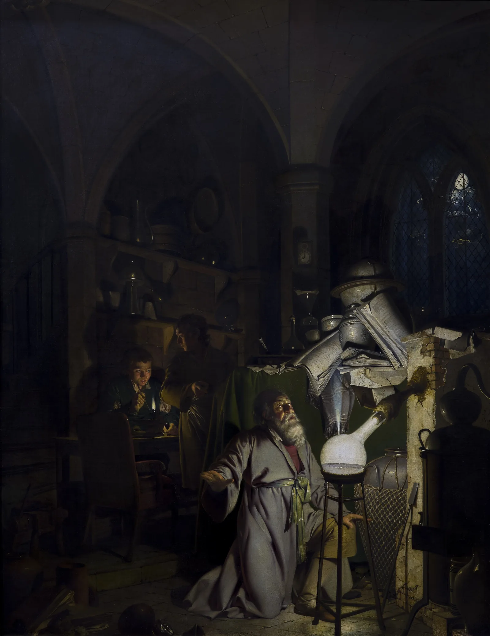 An alchemist kneels before a glowing vessel in a vaulted workshop, with assistants and equipment behind him.